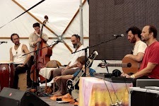 Acoustic ensemble rehearsal playing instruments under a tent pavilion